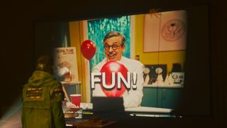 Dylan Faden looking at a projected film of Casper Darling, which is displaying the caption "FUN!" in large text.