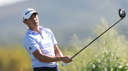 Collin Morikawa watches his shot after hitting a drive