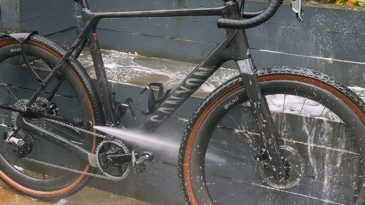 Muc-Off Mobile Bike Pressure Washer rinsing snow foam off a Canyon bike