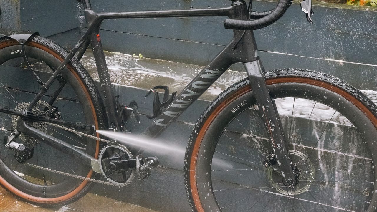 Muc-Off Mobile Bike Pressure Washer rinsing snow foam off a Canyon bike