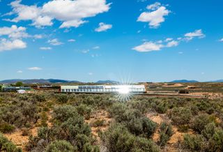 Earthship community in Taos showing colourful off grid homes nestled into the desert earth