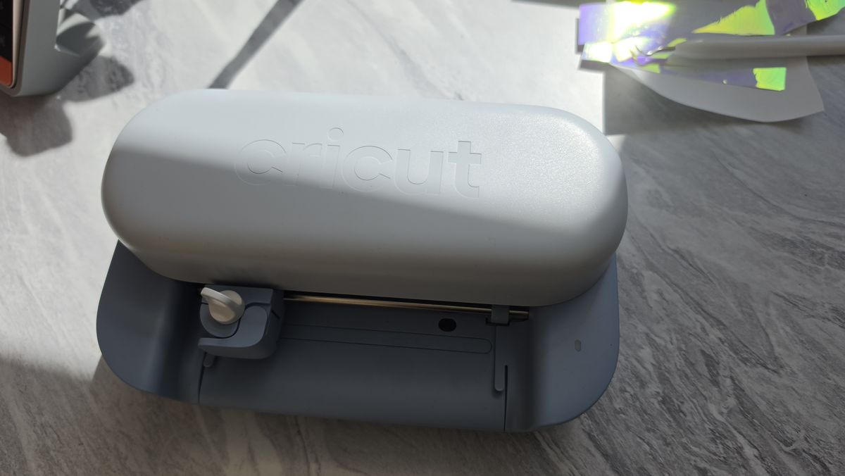 The Cricut Joy 2 on a white marble craft table in natural sunlight
