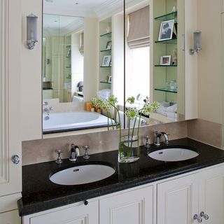 Bathroom with mirror on wall and white cabinet