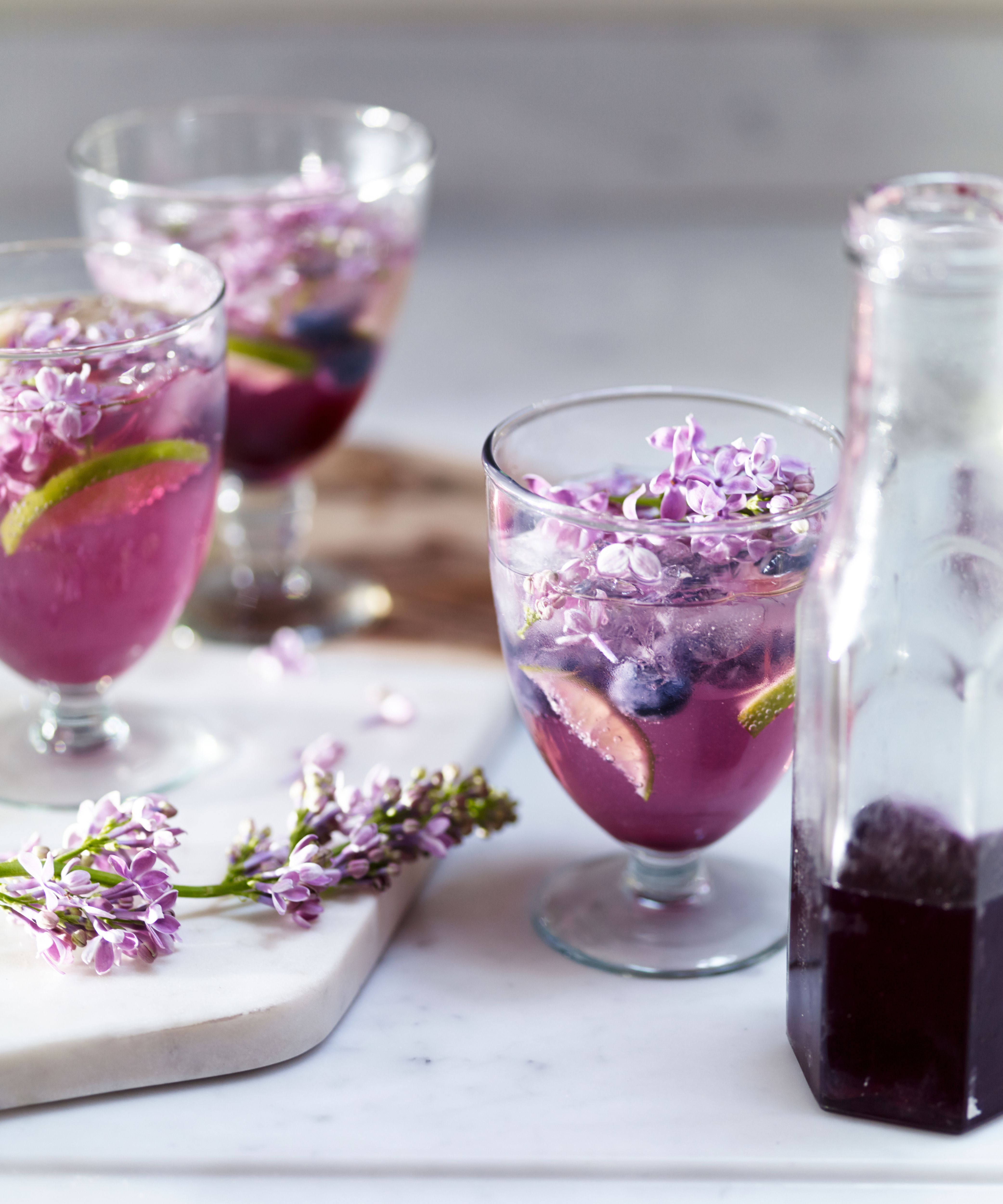 Glasses of pretty pink drinks with fruit and flowers floating in them