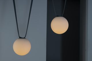 Two spherical lamps hanging from textile ropes