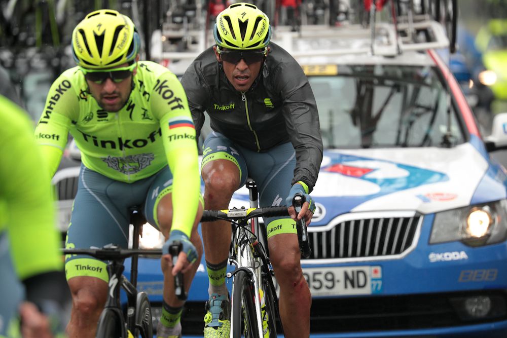 Alberto Contador (R), injured after a fall, rides with a teammate during the 183 km second stage of the 103rd edition of the Tour de France