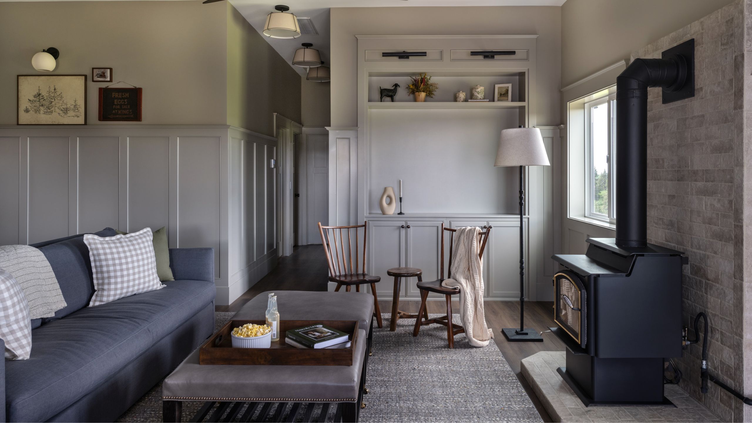 a large open plan living area of a barn retreat with original log burning stove and comfortable vintage furnishings