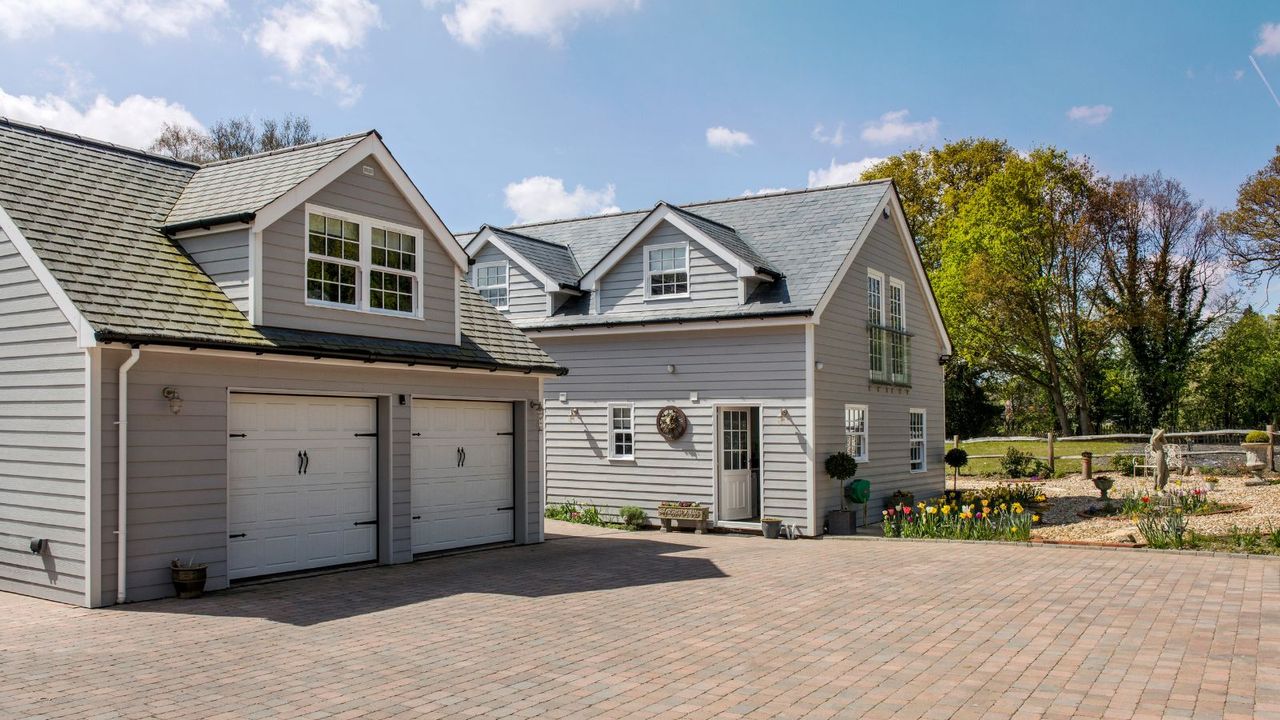 A home with a double garage and a shingle roof 