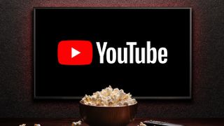 YouTube logo on smart TV with a popcorn bowl and remote control on the table