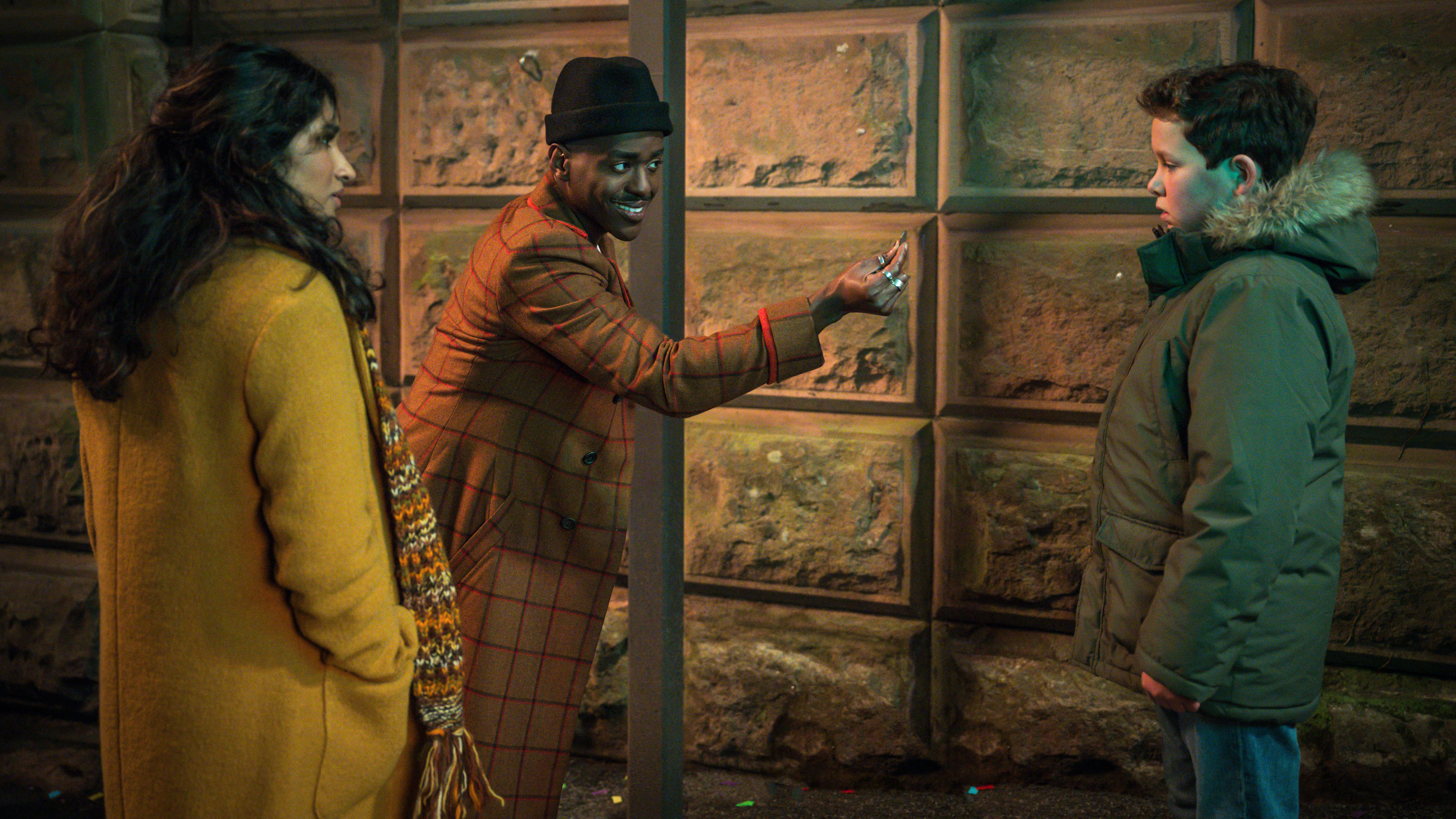 Varada Sethu as Belinda Chandra, Ncuti Gatwa as the Doctor, and Benjamin Chivers as the young Conrad in Doctor Who: 'Lucky Day'.