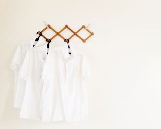 how to remove sunscreen stains - white shirts on hangers - GettyImages-1140091714