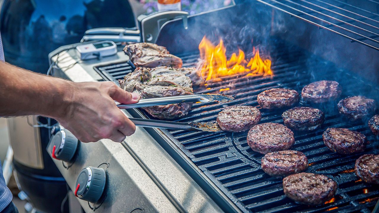 cooking burgers and lamb on a gas grill