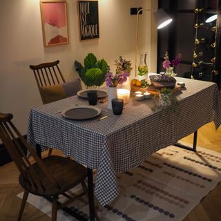 dining table with wooden chairs and flower vase with candle