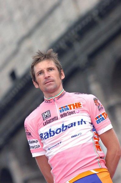 Maglia rosa Denis Menchov on the podium while the Russian national anthem plays.