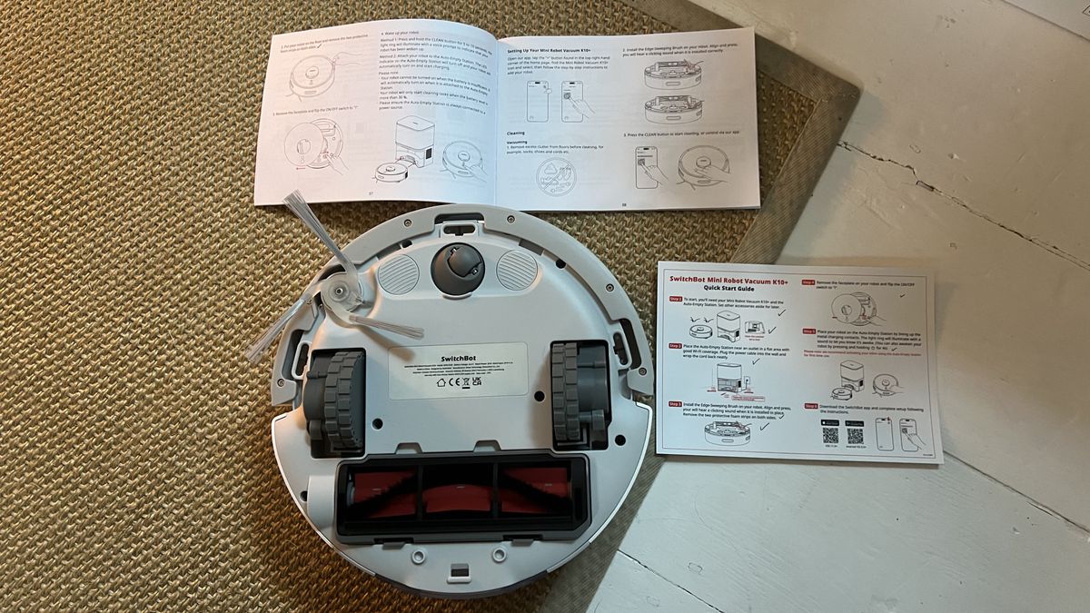 Underaside of the SwitchBot Mini Robot Vacuum K10+ along with quick start guide and manual