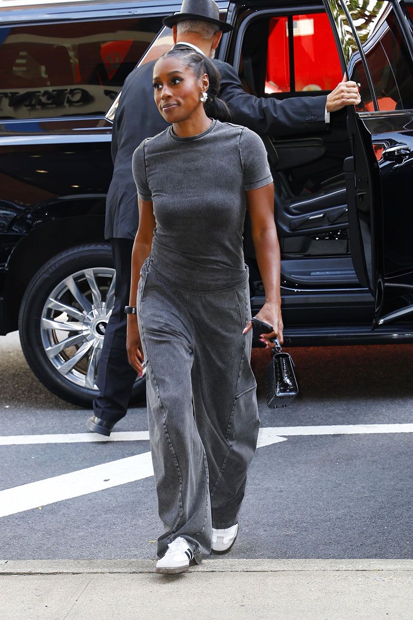 Issa Rae wearing a gray T-shirt, gray pants, and white Adidas samba sneakers