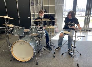 Students from Upperman High School in Baxter, TN, shown playing a new DW drum kit and a practice pad, which were part of a recent grant from the Guitar Center Music Foundation.