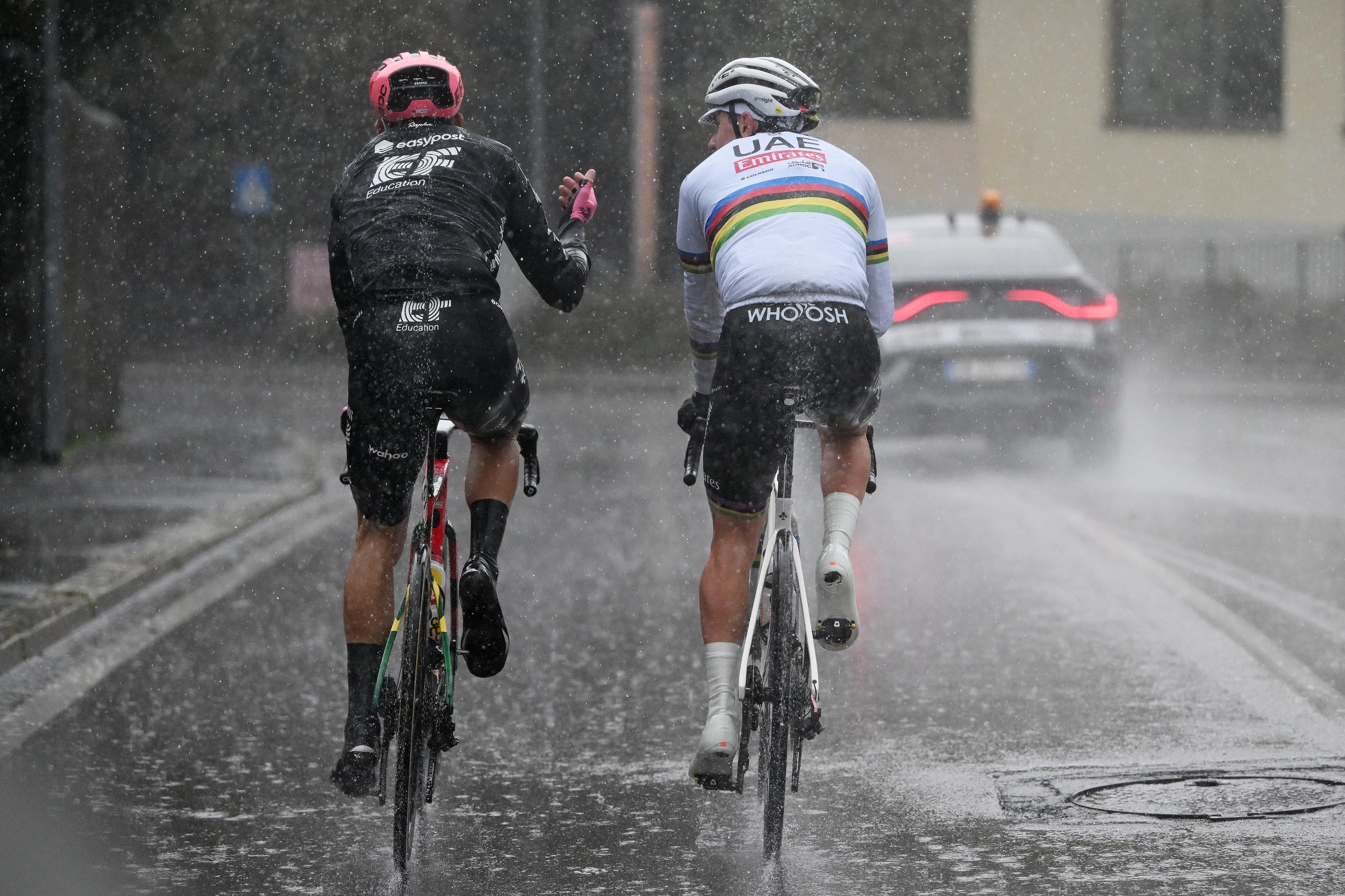 Tadej pogacar chats with an EF rider in heavy rain