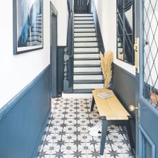 White painted hallway with blue panelling and star patterned floor tiles