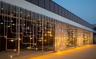 Midnight Palace, Future Firm 2021. A wall made of different shaped metal rods with lights at the end of each.