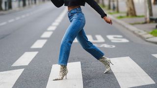 Emilie Joseph wears blue ribcage Levi's denim jeans and snake boots in Paris, France