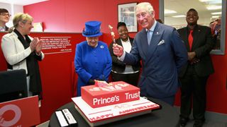 Queen Elizabeth II and King Charles cutting a 'Prince's Trust' cake