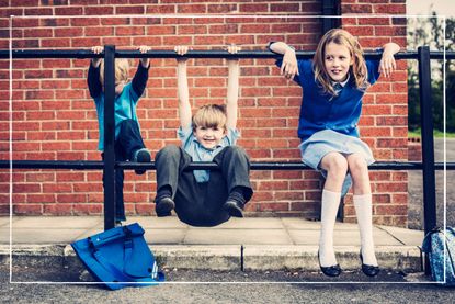 school kids of different ages playing on railing at school