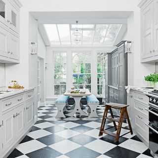 dining area with white wall and cabinets with ladder