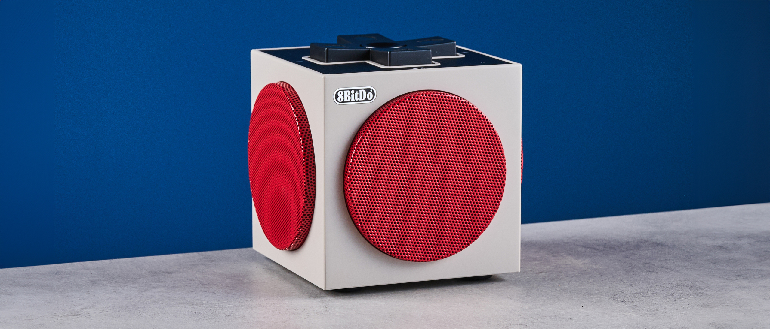 A beige, red and black 8BitDo Retro Cube 2 Bluetooth speaker