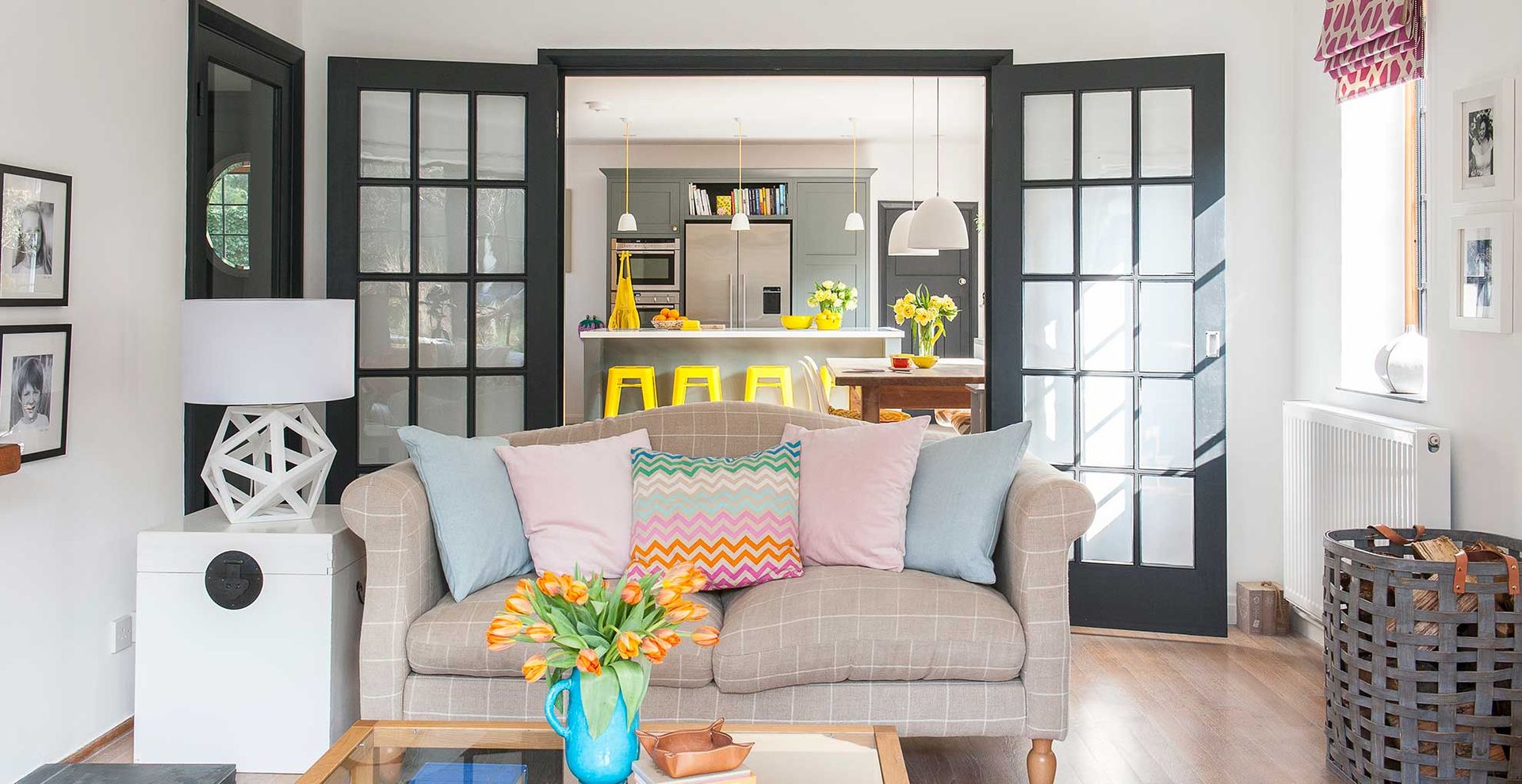 white living room with doors that lead through to a kitchen