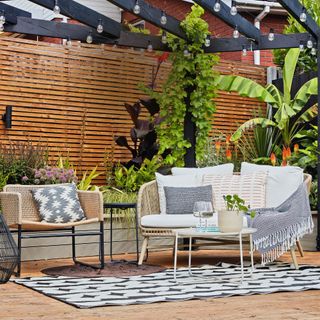 decking area with outdoor rug and seating with blankets and cushions