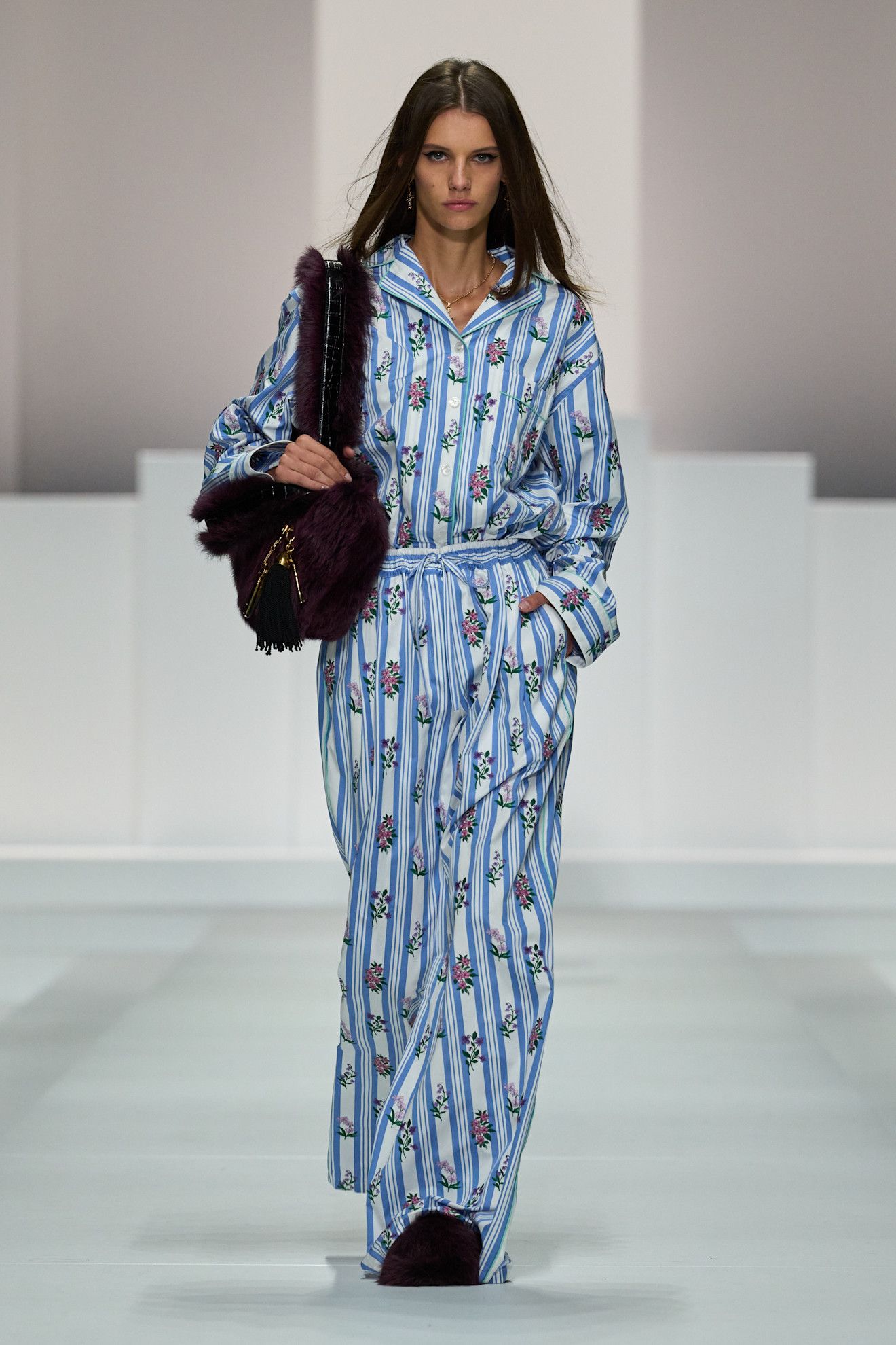 A model on dolce & Gabbana runway wears a pajama-inspired outfit with flroals.
