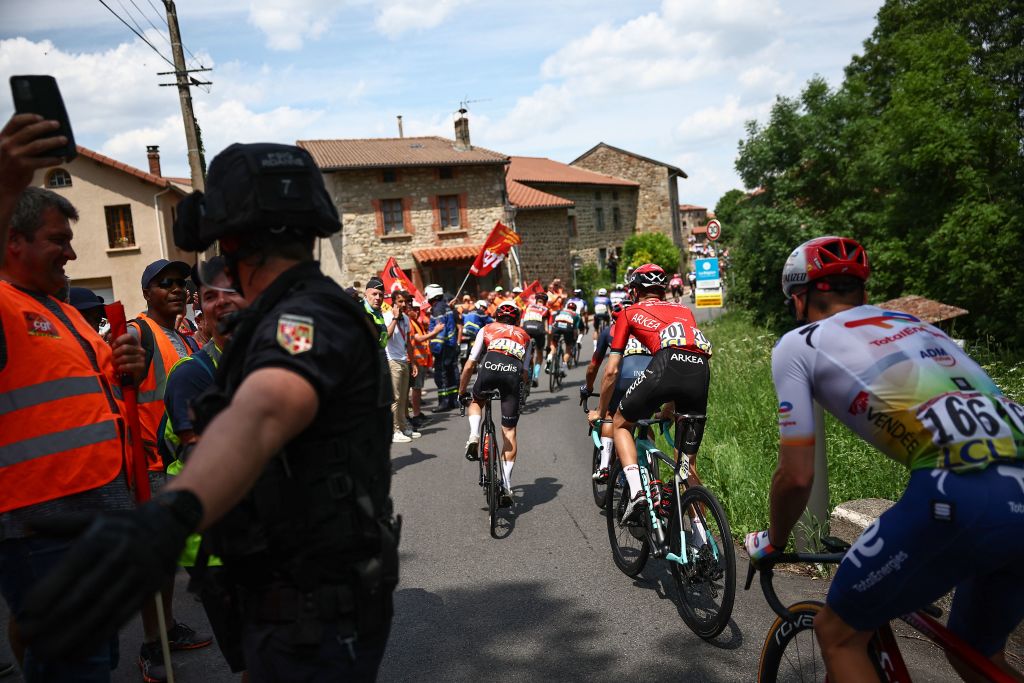 Critérium du Dauphiné stage 3: riders make their way past a mid-stage protest