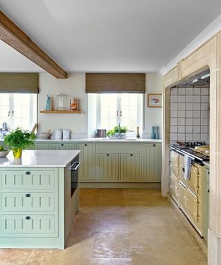 country kitchen with pale green cabinets, pale worktops and Aga in Georgian style Cotswolds newbuild country house