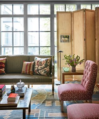 eclectic living room with French oak screen, striped sofa and pink chairs