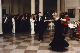 John Travolta twirls Princess Diana on the dance floor while at a White House banquet. Ronald and Nancy Reagan can be seen in the background