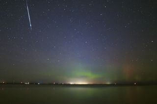Taurid meteorite fireball descending in glowing aurora over Lake Simcoe on November 9, 2015. 20,000-year-old Taurid meteor is said to be 20,000 years old.