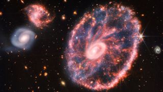 A composite image of the Cartwheel Galaxy and two smaller companion galaxies.