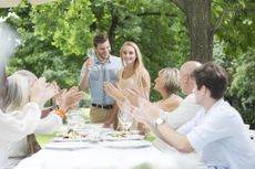 People clapping hands for young couple on a garden party