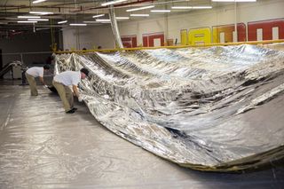Technicians at L'Garde, the primary contractor for the Sunjammer mission, work carefully with the enormous solar sail.