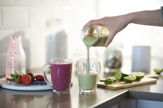 Freshly made smoothies poured into glasses.