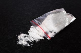 Mephedrone powder, or bath salts, in a small bag.