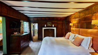 The master suite comprised of a large bed in an old wooden room at Ockenden Manor