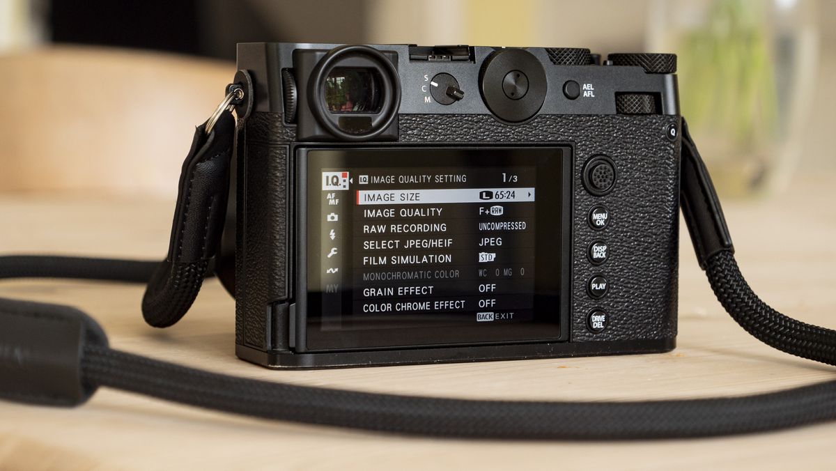 All-black Fujifilm GFX100RF rangefinder-style camera on a wooden table