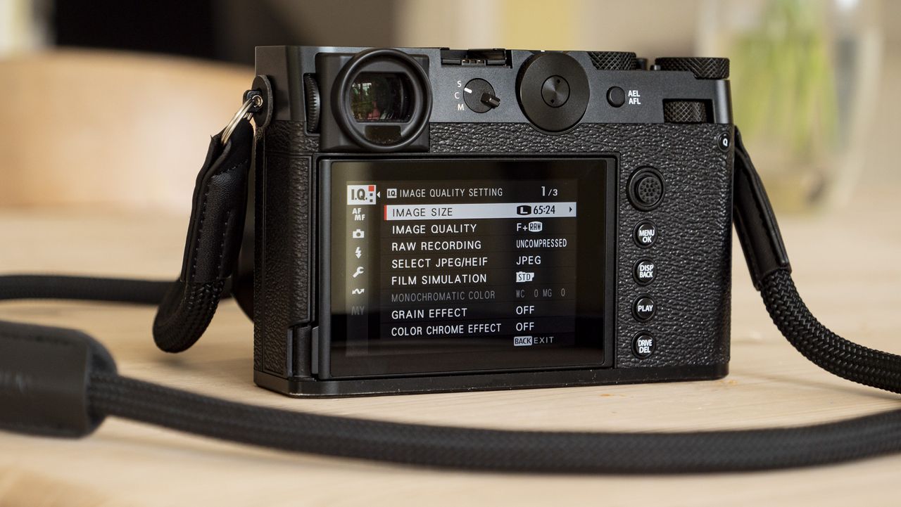 All-black Fujifilm GFX100RF rangefinder-style camera on a wooden table