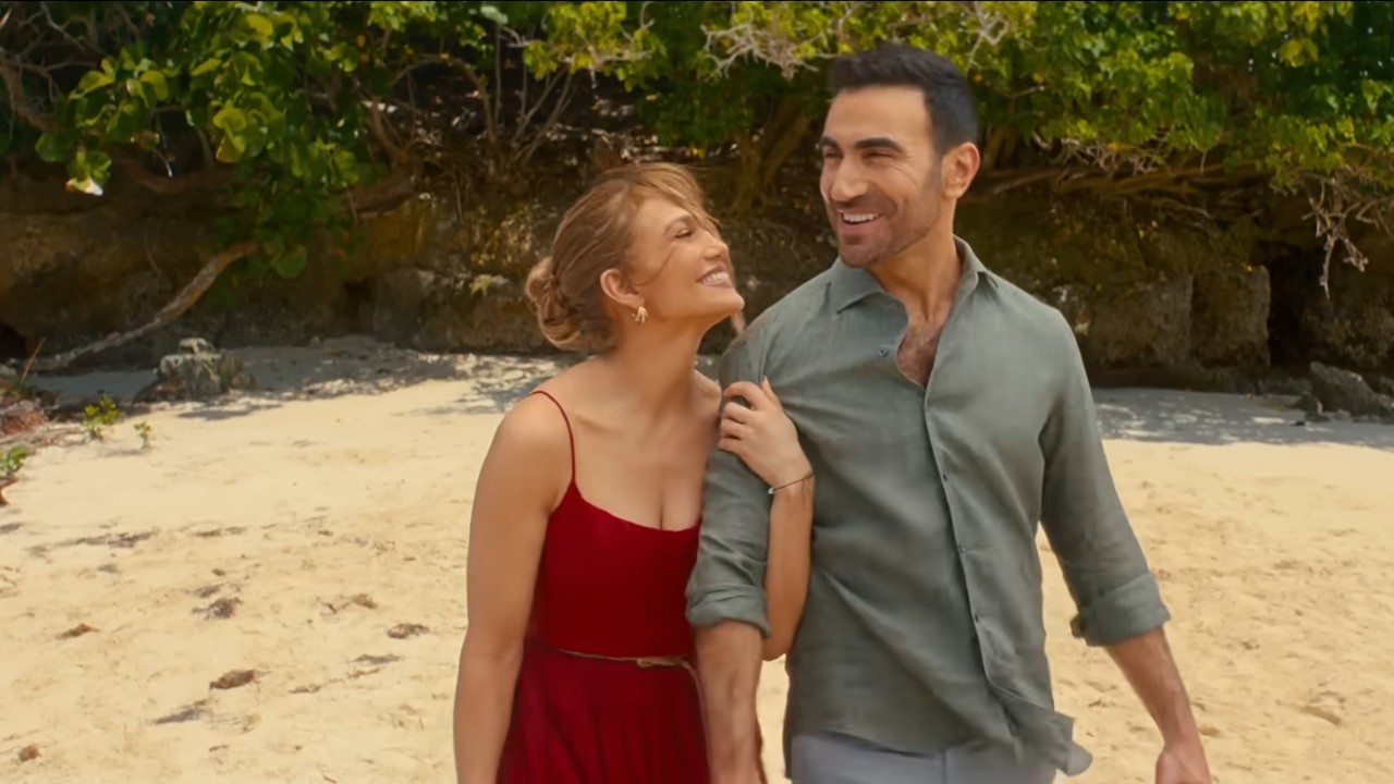 Jennifer Lopez holding on Brett Goldstein's arm on Office Romance.