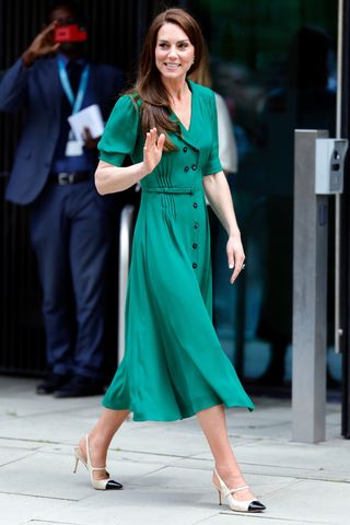 Catherine, Princess of Wales wears a green dress and white and black heels as she visits the Anna Freud Centre, a children's mental heath charity of which she is patron, on May 18, 2023 in London, England.