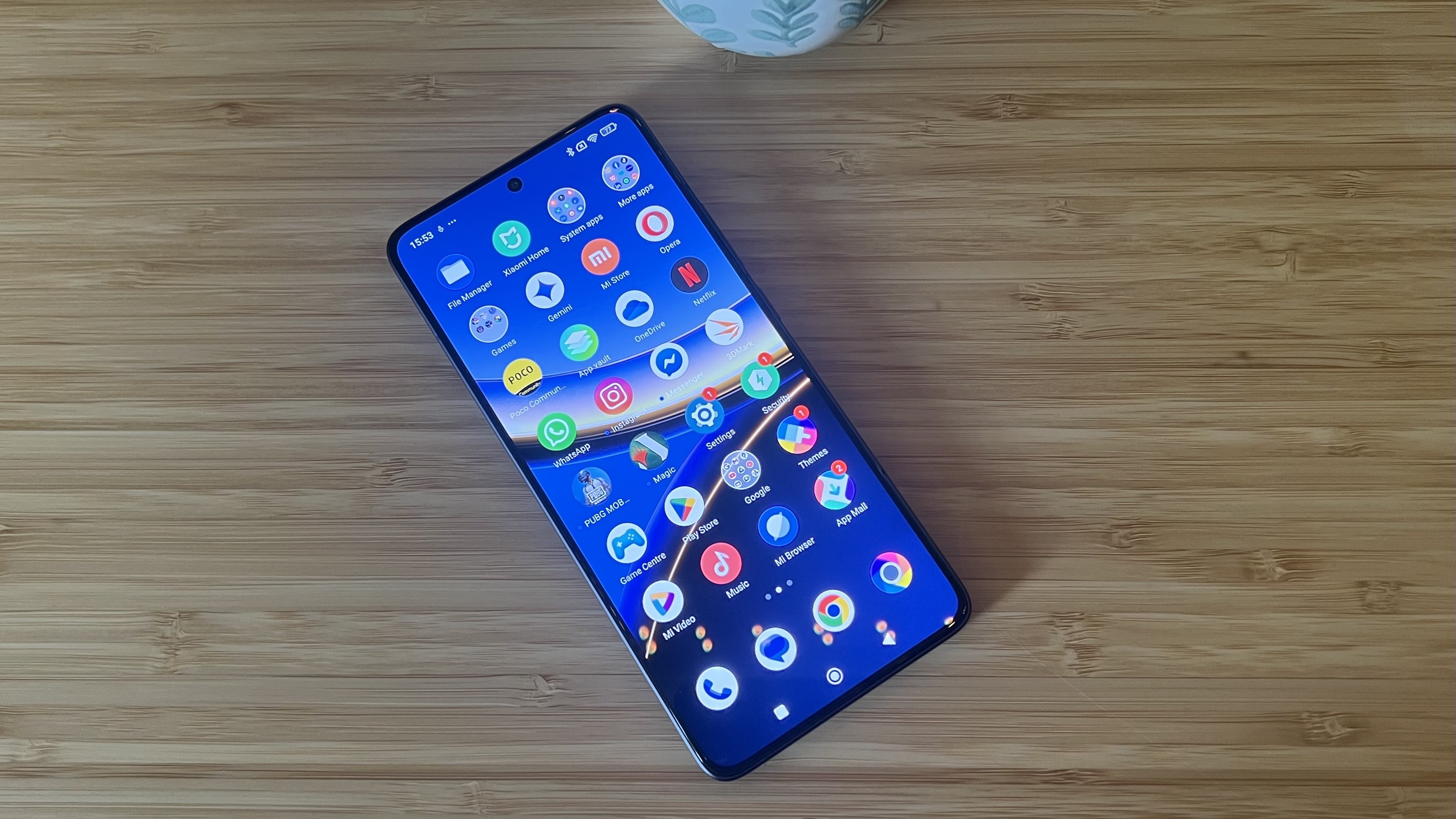 Poco F7 Pro phone showing icons while on a wooden desk