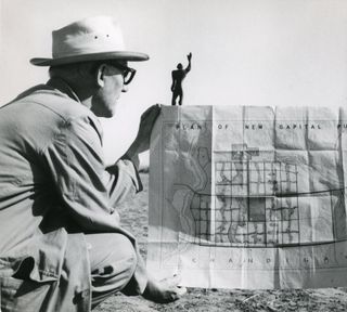 Le Corbusier in Chandigarh with the plan of the city and a model of the Modular Man, his universal system of proportion, 1951 © FDL, ADAGP 2014