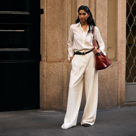 woman standing on the sidewalk in an all-white outfit